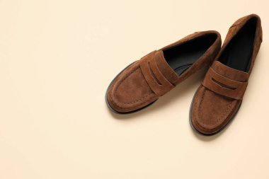 Bej arka planda bir çift şatafatlı deri ayakkabı, üst manzara. Metin için boşluk