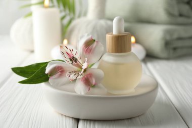Güzel bir spa kompozisyonu, temel yağ ve yanan mumlar beyaz ahşap masada, yakın plan.