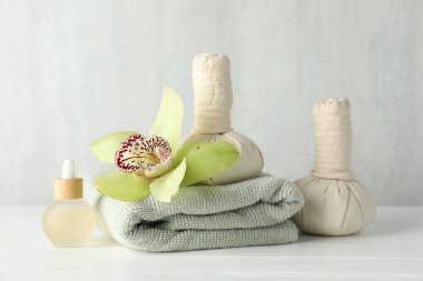 Beyaz ahşap masa üzerinde bitkisel poşetlerle güzel bir spa kompozisyonu.
