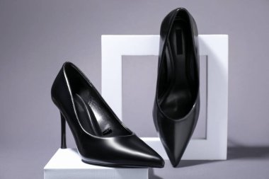 Pair of stylish high heeled shoes on gray background, closeup