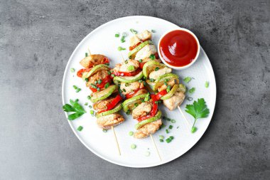 Tavuk, sebze, sos ve yeşil soğanlı lezzetli şişler.