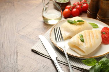 Lezzetli ızgara kalamar, domates, fesleğen ve çatal bıçak parçaları, yakın plan. Metin için boşluk