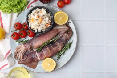 Raw squids, stuffing and products on white tiled table, flat lay. Space for text