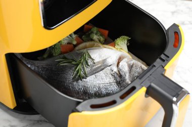 Çiğ balık, limon ve sebzeler tavada, beyaz mermer masada, yakın plan.