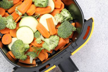 Çiğ havuç, brokoli ve kabak açık gri masada, kabak kızartma makinesinde.