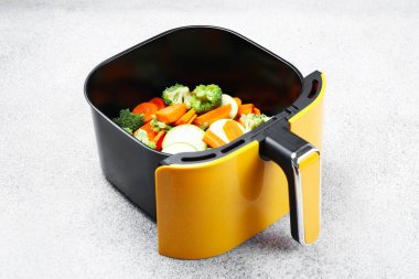 Çiğ havuç, brokoli ve kabak açık gri masada tavada.