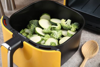 Çiğ brokoli ve kabağı gri masadaki tavada kes, yakın plan.