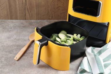 Çiğ brokoli ve kabağı gri masadaki kızartma makinesinde kes.