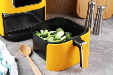 Çiğ brokoli ve kabağı gri masadaki kızartma makinesinde kes.