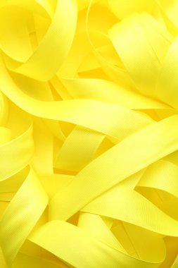 Beautiful yellow ribbons as background, top view