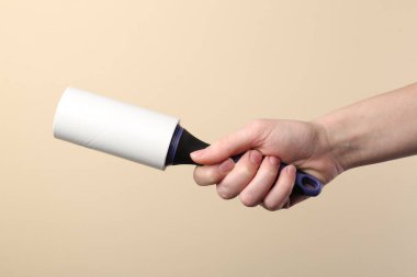 Bej arka planda pamuklu silindirli kadın, yakın plan.