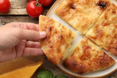 Ahşap masada nefis bir parça Megrelian Khachapuri alan kadın, yakın plan.