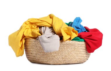 Hasır çamaşır sepeti beyaza izole edilmiş renkli kıyafetlerle dolu.