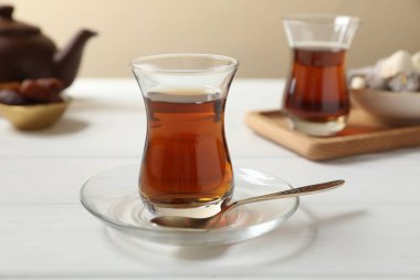 Geleneksel Türk çayı bardakta beyaz ahşap masada, yakın plan