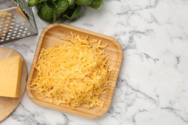 Beyaz mermer masa üzerinde rendelenmiş peynir, rende ve ürünler. Metin için boşluk