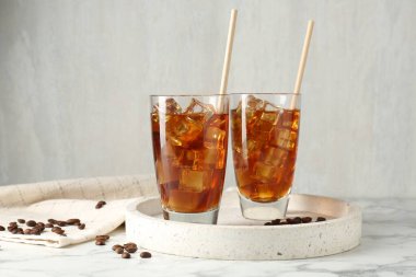 Lezzetli buzlu kahve ve fasulye beyaz mermer masada.