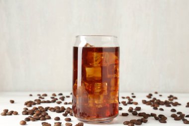 Lezzetli buzlu kahve ve fasulye beyaz ahşap masada.