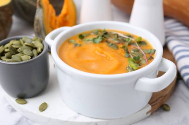 Çekirdekli balkabağı çorbası ve masada mikro yeşiller, yakın plan.