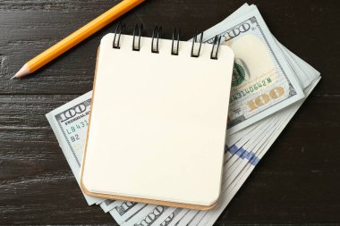 Alimony. Notebook, money and pencil on wooden table, flat lay