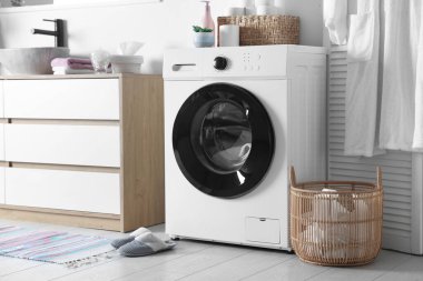 Çamaşır makinesi ve çamaşır sepeti banyoda lavabonun yanında. İç tasarım