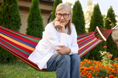 Hamakta dinlenen güzel, son sınıf öğrencisi kadın.