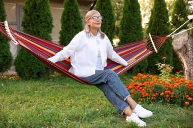 Hamakta dinlenen güzel, son sınıf öğrencisi kadın.