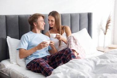 Hoş bir çift evde sıcak içeceklerin tadını çıkarıyor.