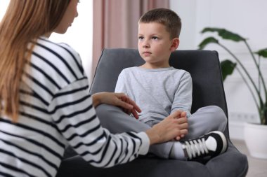 Anne üzgün oğlunu evde destekliyor, yakın plan.