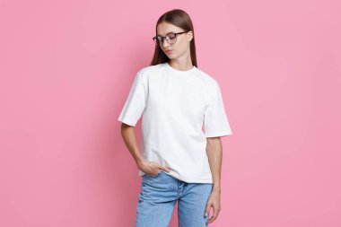 Pembe arka planda beyaz tişört giyen bir kadın. Tasarım için model