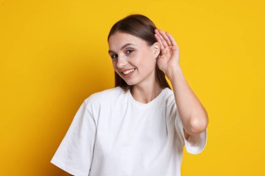 Turuncu arka planda el ele hareket eden bir kadın.