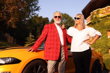 Modern Cabriolet yakınlarında güneş gözlüklü şık bir çift.