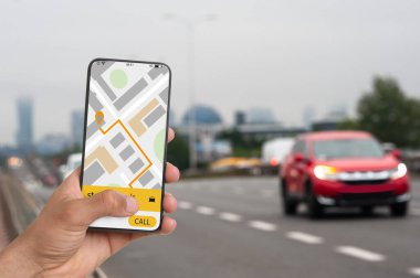 Şehir caddesinde taksi çağırmak için cep telefonu uygulaması kullanan bir adam.