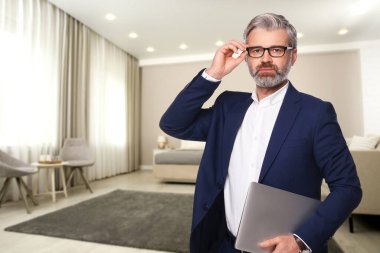 Geniş odada dizüstü bilgisayarı olan bir otel yöneticisi.