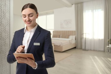 Odada tablet bilgisayarı olan bir otel yöneticisi.