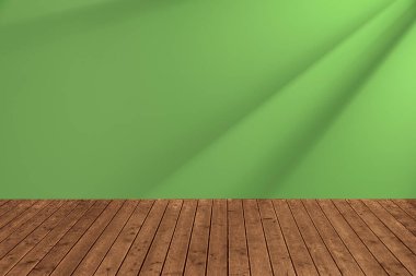 Yeşil duvara karşı güneş ışığıyla aydınlatılmış ahşap zemin. Tasarım için boşluk