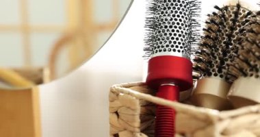 Saç şekillendirme. Kapalı alanda ahşap gösteriş için farklı tarak ve fırçalar, yakın plan. Kamera sola hareket ediyor