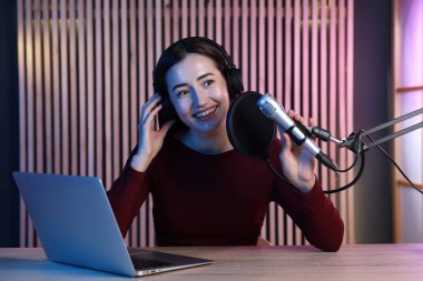 Podcast sunucusu stüdyoda talk show kaydediyor.