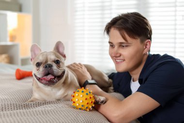 Adam evde tatlı Fransız bulldoguyla oynuyor.