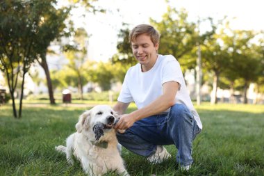 Adam parkta sevimli golden retriever köpeğiyle oynuyor. Metin için boşluk