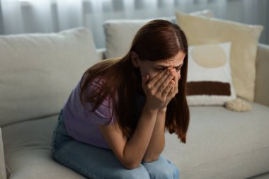 Evdeki kanepede ağlayan bir kadın. Keder ve yalnızlık