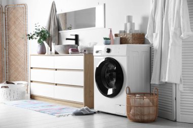 Çamaşır makinesi ve çamaşır sepeti banyoda lavabonun yanında. İç tasarım