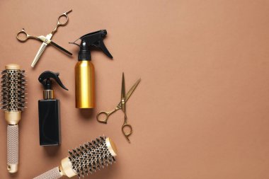 Different hair styling tools on brown background, flat lay. Space for text