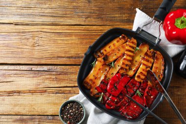 Ahşap masa üzerinde baharatlı ızgara biber, düz yatak. Metin için boşluk