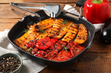 Ahşap masada baharatlı ızgara biber, yakın plan.