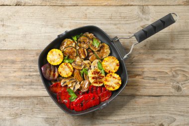 Ahşap masada nefis ızgara sebzeler, mantarlar ve maydanoz.