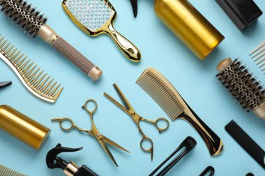 Different hair styling tools on light blue background, flat lay