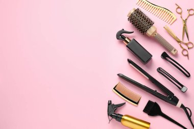 Different hair styling tools on pink background, flat lay. Space for text