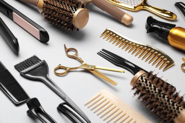 Beyaz arkaplanda farklı saç şekillendirme araçları, yakın plan