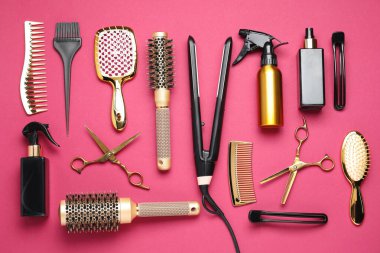 Different hair styling tools on pink background, flat lay