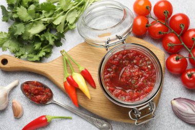 Kavanozda salsa sosu ve ışık masasında malzemeler.